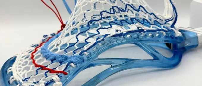Lacrosse head with intricate stringing design.