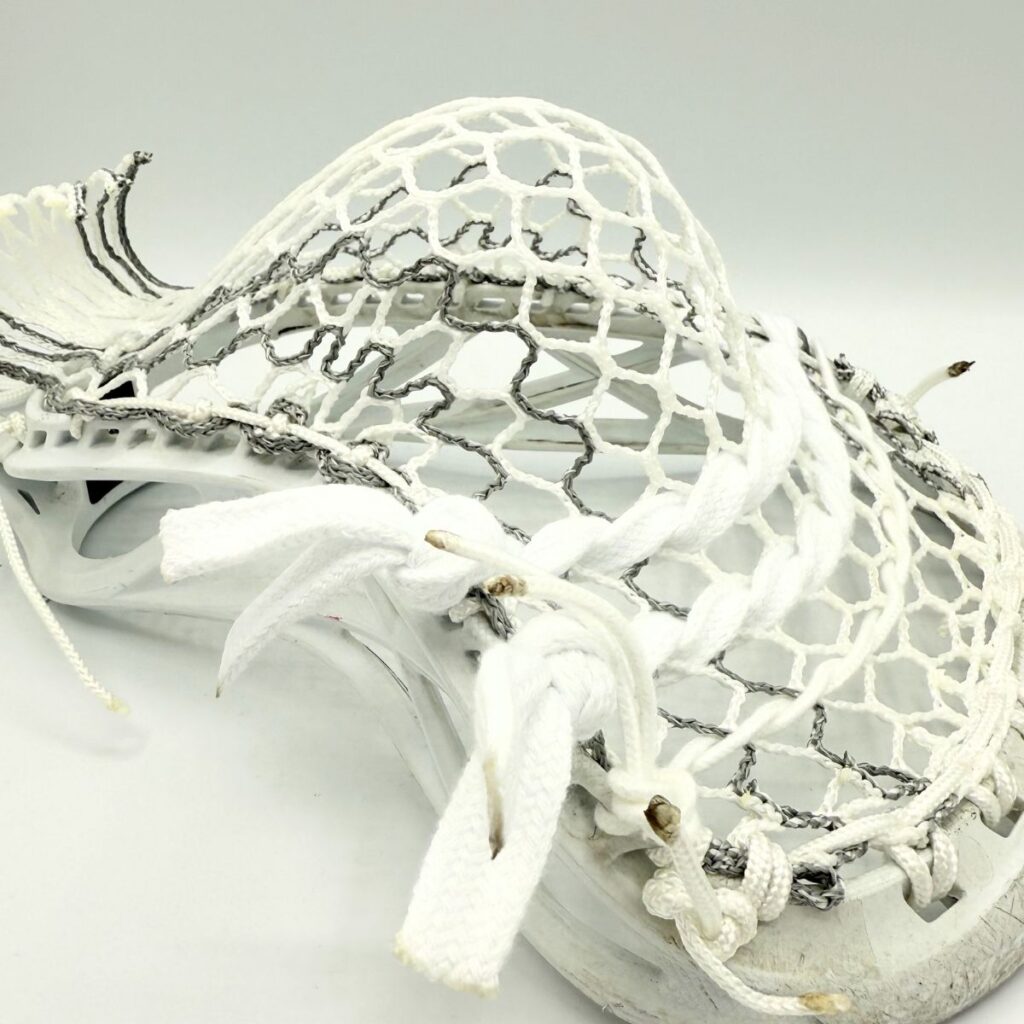 Side view of an ECD Delta defense head showing the mid-high pocket shift and specialized sidewall tension for localized ball control.