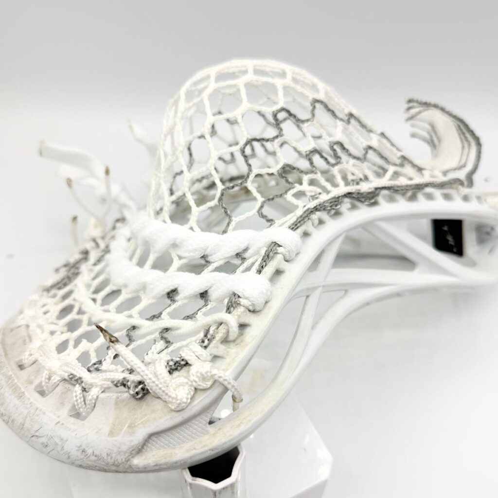 Side view of an ECD Delta defense head showing the mid-high pocket shift and specialized sidewall tension for localized ball control.
