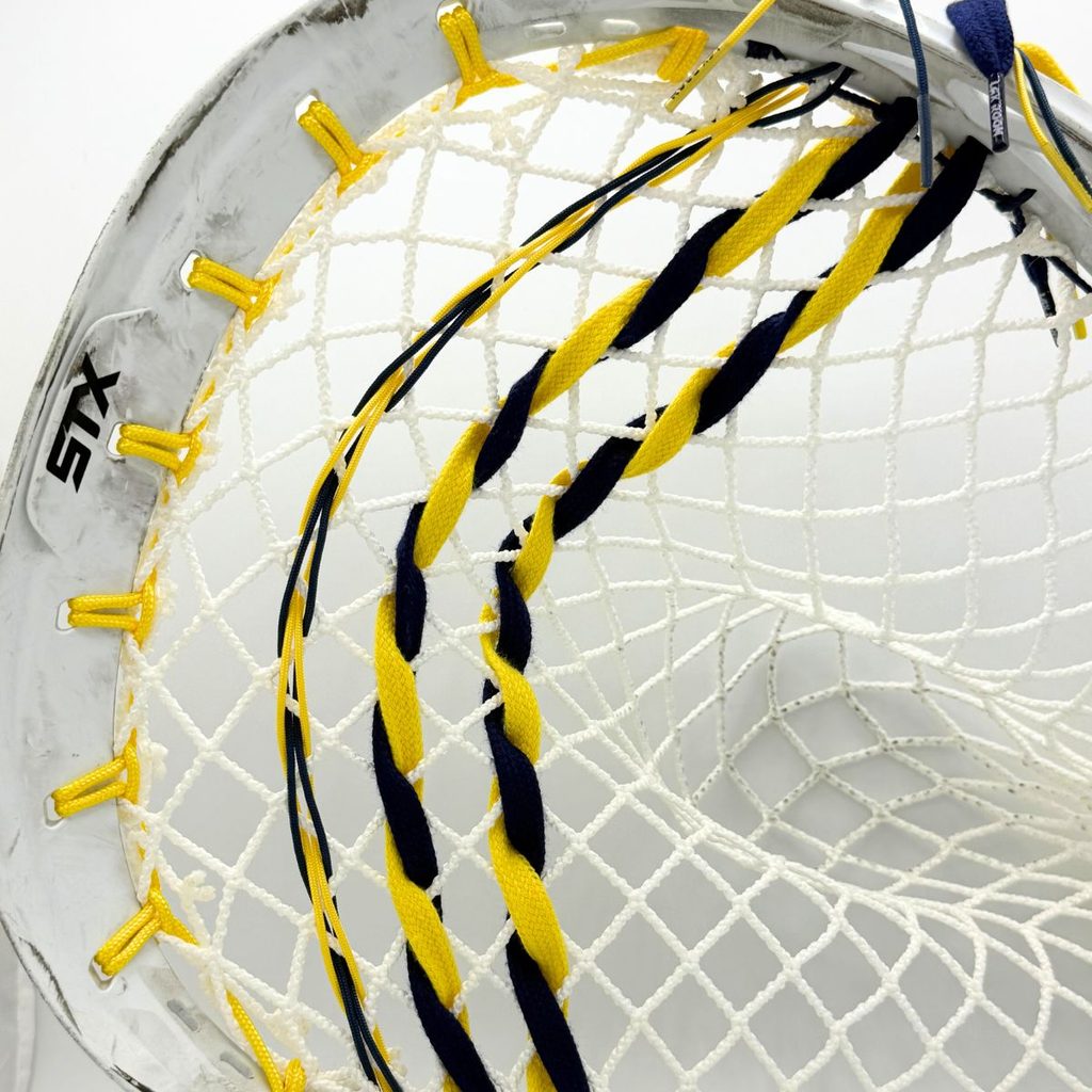 closeup of stx eclipse ii sidewall with yellow sidewall string, navy and yellow shooters and white ecd impact 12d semisoft goalie mesh