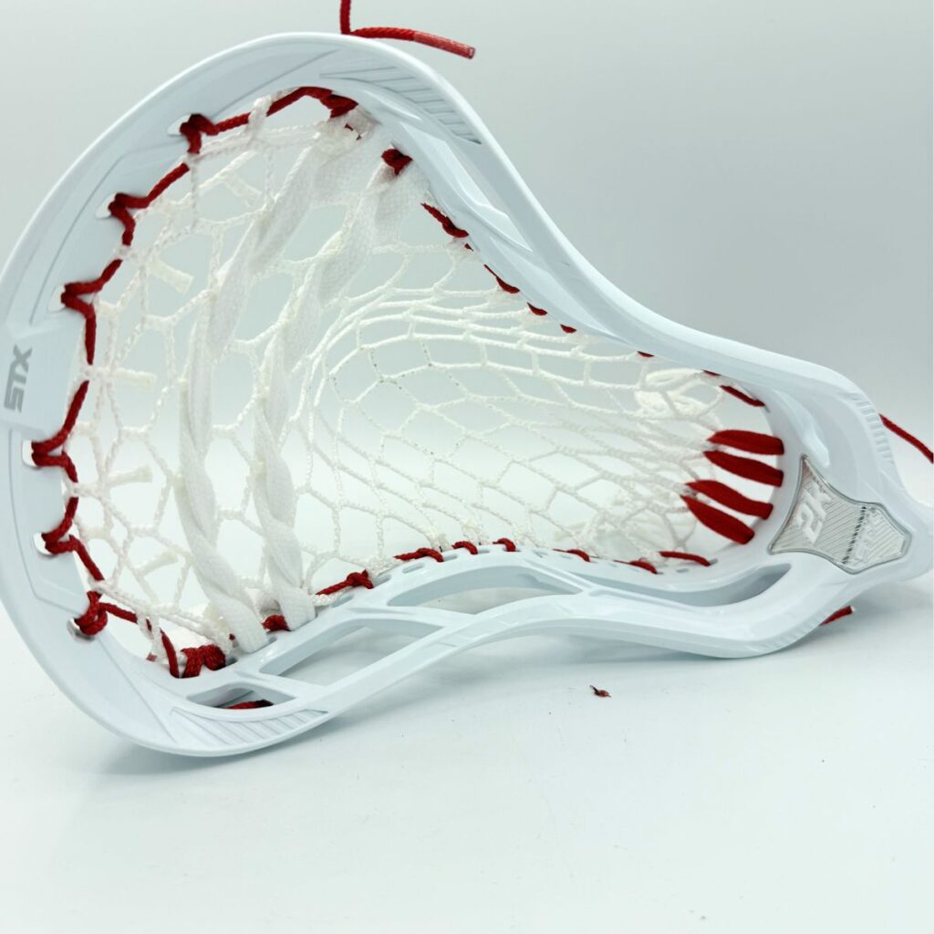 STX Magnet 2k defensive lacrosse head with ECD Hero 4.0 7-diamond mesh — front face view showing mid-high pocket channel and red sidewalls
