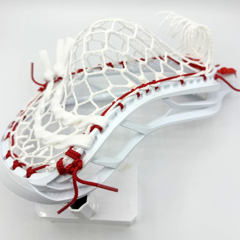 STX Magnet 2k strung with ECD Hero 4.0 7-diamond mesh — angled rear view showing bottom string knots and red sidewall ties
