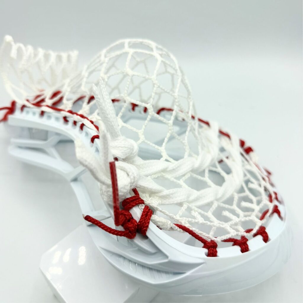 Close-up of STX Magnet 2k lacrosse pocket bottom — ECD Hero 4.0 7-diamond mesh with red sidewall string and shooting string knot detail