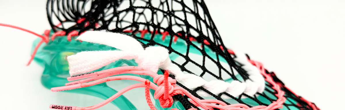 Close-up of STX Stallion Prism sidewall with coral pink LaxRoom strings and black G3 XL mesh in a midfielder mid pocket