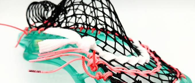 Close-up of STX Stallion Prism sidewall with coral pink LaxRoom strings and black G3 XL mesh in a midfielder mid pocket