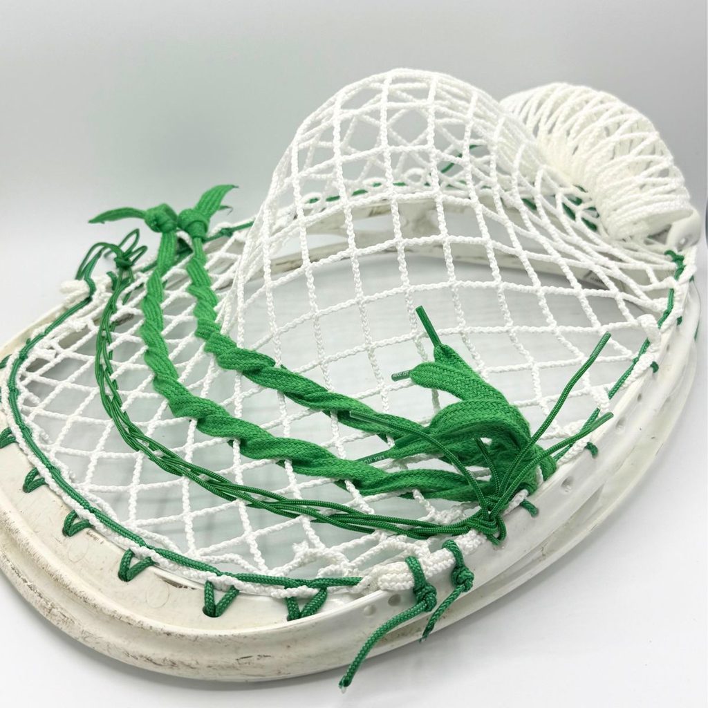 angled view of ecd impact 12d semihard goalie pocket in a warrior void noz head with white top string, green sidewall and green shooting strings