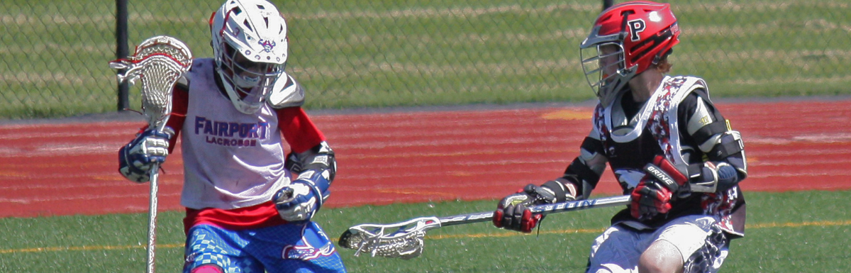 youth lacrosse defender guarding a youth lacrosse attackman